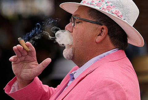 Paul Anderson smokes a cigar before the 152nd running of the Kentucky Derby horse race at Churchill Downs, in Louisville, Kentucky.
