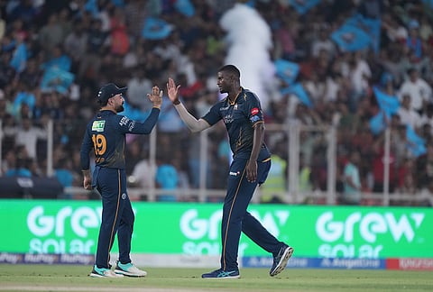 Gujarat Titans' Jason Holder, right, celebrates the wicket of Punjab Kings' Marcus Stoinis with Rashid Khan during the Indian Premier League cricket match between Gujarat Titans and Punjab Kings in Ahmedabad.