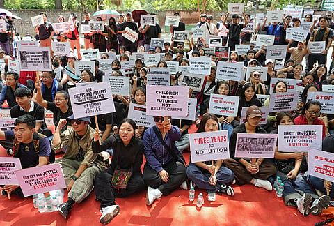 People hold placards during a protest on the third anniversary of the Manipur violence, at Jantar Mantar, in New Delhi.