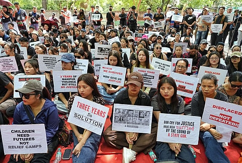 People hold placards during a protest on the third anniversary of the Manipur violence, at Jantar Mantar, in New Delhi.