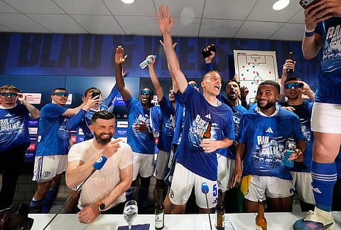 Schalke's players crash the late press conference of head coach Miron Muslic with beer after FC Schalke 04 secured promotion to the German Bundesliga by winning the Bundesliga 2 match against Fortuna Duesseldorf at the Arena in Gelsenkirchen, Germany
