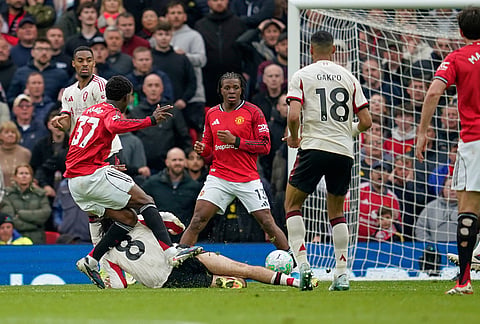 Manchester United's Kobbie Mainoo, left, scores his side's third goal during the English Premier League soccer match between Manchester United and Liverpool in Manchester, England.