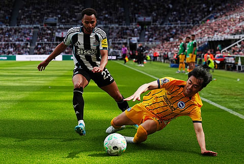 Newcastle United's Jacob Murphy, left, and Brighton and Hove Albion's Kaoru Mitoma battle for the ball during their English Premier League soccer match in Newcastle, England.