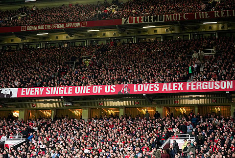 Manchester United fans cheer during the English Premier League soccer match between Manchester United and Liverpool in Manchester, England.