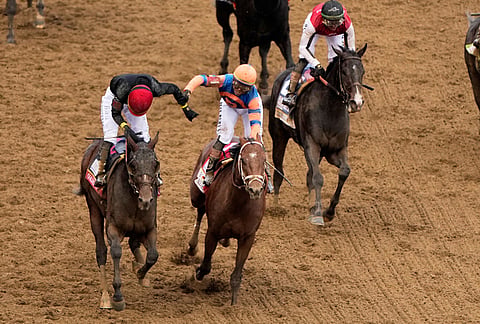 Jockey Jose L. Ortiz, left, is congratulated by Irad Ortiz, Jr. atop Renegade, after riding Golden Tempo to victory during the 152nd running of the Kentucky Derby horse race at Churchill Downs, in Louisville, Kentucky.