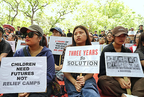 People hold placards during a protest on the third anniversary of the Manipur violence, at Jantar Mantar, in New Delhi.