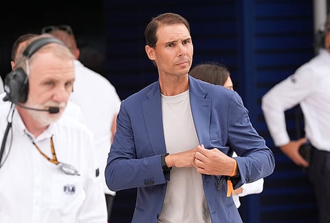 Rafael Nadal walks through the pit area during the qualifying session of the of the Miami Formula One Grand Prix auto race, in Miami Gardens, Florida.