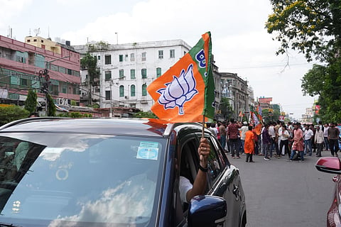 BJP workers celebrate as trends show the party leading in the West Bengal Assembly elections, in Kolkata.