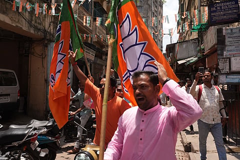 BJP workers celebrate as trends show the party leading in the West Bengal Assembly elections, in Kolkata.