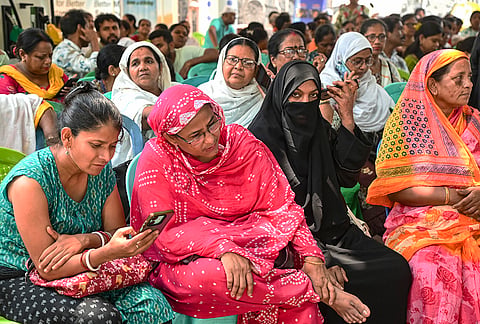 TMC workers watch the election results near a counting centre during the West Bengal Assembly elections results day in Kolkata.