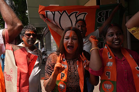 BJP workers celebrate as trends show the party leading in the West Bengal Assembly elections, in Kolkata.