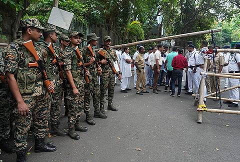 Security personnel stand guard outside a vote counting centre during the West Bengal Assembly election results day, in Kolkata.