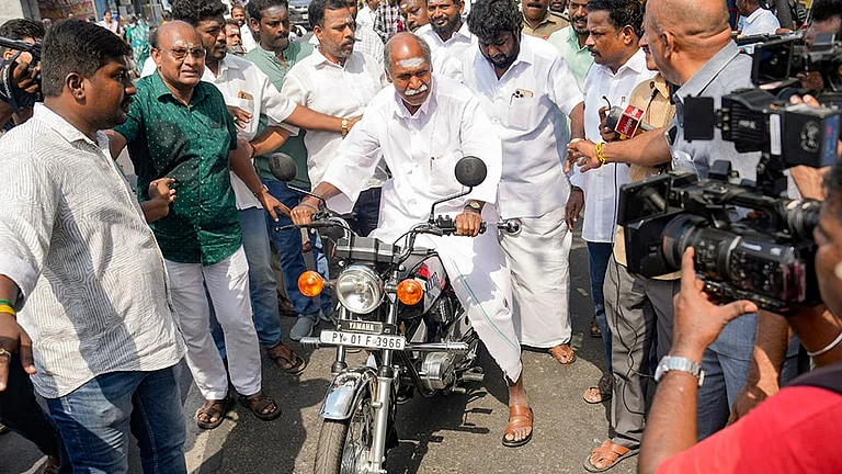 Puducherry Chief Minister N Rangasamy leaves on a motorcycle after casting vote during the Puducherry Assembly elections, at a polling station in Puducherry. - | Photo: PTI/R Senthilkumar