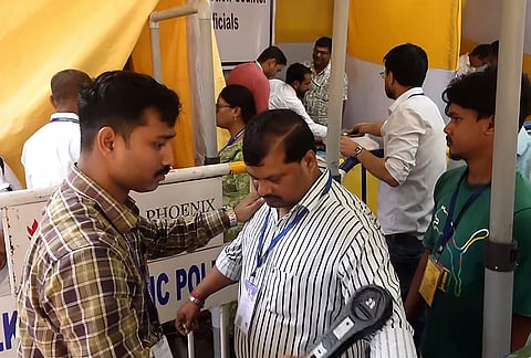 Security personnel frisk a person outside a vote counting centre during the West Bengal Assembly election results, in Kolkata.