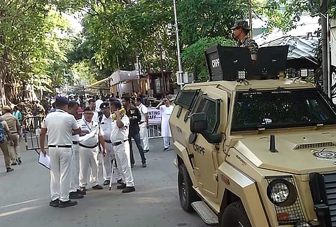 Security personnel and officials outside a vote counting centre during the West Bengal Assembly election results day, in Kolkata.