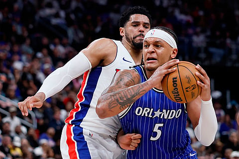 Orlando Magic forward Paolo Banchero (5) drives to the basket against Detroit Pistons forward Tobias Harris, left, during the second half in Game 7 of a first-round NBA basketball playoffs series in Detroit.