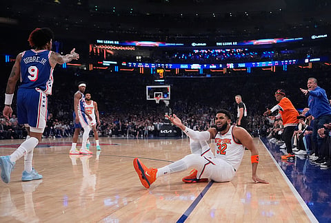New York Knicks' Karl-Anthony Towns, center, reacts after getting knocked to the ground during the first half of Game 1 in a second-round NBA basketball playoffs series against the Philadelphia 76ers in New York. 