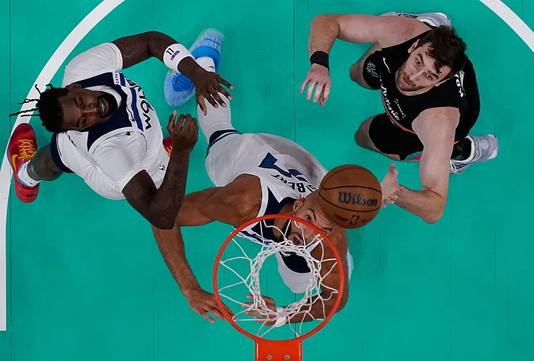 Minnesota Timberwolves center Naz Reid, left, center Rudy Gobert, center, and San Antonio Spurs center Luke Kornet, right, eye a rebound during the first half in Game 1 of a second-round NBA playoffs basketball series in San Antonio.
- | Photo: AP/Eric Gay