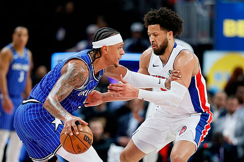 Orlando Magic forward Paolo Banchero, left, drives against Detroit Pistons guard Cade Cunningham, right, during the first half in Game 7 of a first-round NBA basketball playoffs series in Detroit.