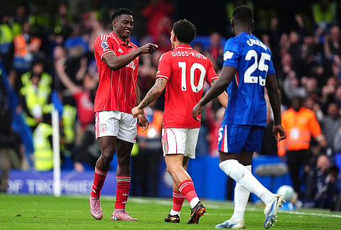 Nottingham Forest's Taiwo Awoniyi, left, celebrates scoring their side's third goal with teammate Morgan Gibbs-White during the English Premier League soccer match between Chelsea and Nottingham Forest in London.