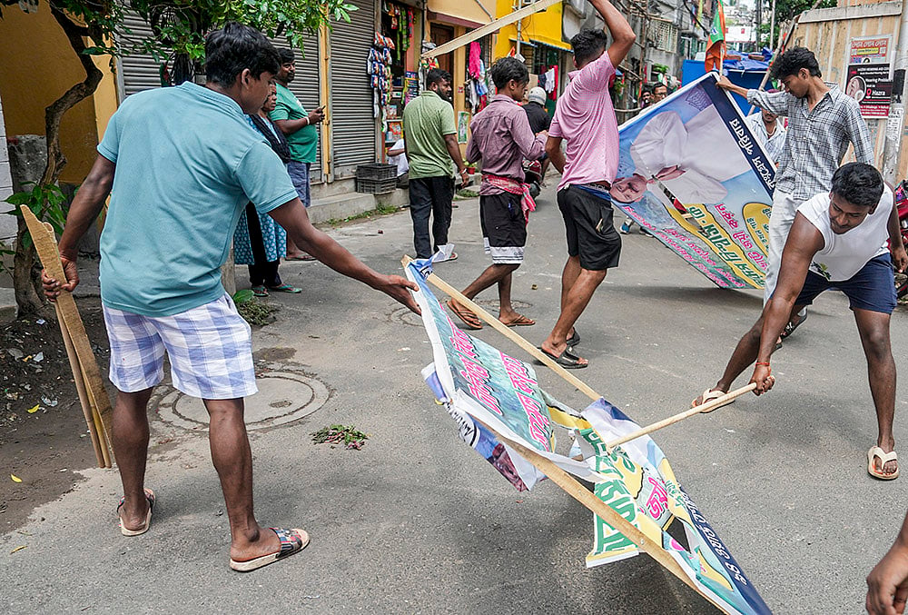 WB polls: BJP supporters remove hoarding