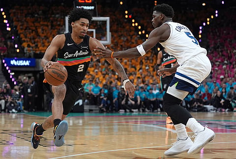 San Antonio Spurs guard Dylan Harper (2) works toward the basket as Minnesota Timberwolves guard Anthony Edwards (5) defends during the first half in Game 1 of a second-round NBA playoffs basketball series in San Antonio.
