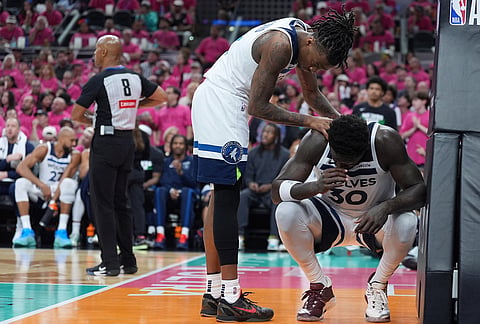 Minnesota Timberwolves guard Bones Hyland (8) checks on forward Julius Randle (30) during the second half in Game 1 of a second-round NBA playoffs basketball series against the San Antonio Spurs in San Antonio.