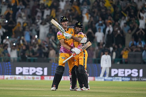 Peshawar Zalmi's Aaron Hardie, left, celebrates with Farhan Yousuf after winning the Pakistan Super League final cricket match against Hyderabad Kingsmen, in Lahore, Pakistan.