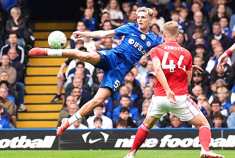 Chelsea's Jesse Derry, left, attempts a shot towards goal during the English Premier League soccer match between Chelsea and Nottingham Forest in London.