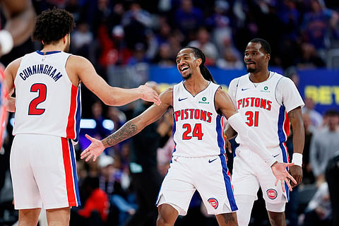 Detroit Pistons guard Daniss Jenkins (24) celebrates with guards Cade Cunningham (2) and Javonte Green (31) after sinking a three-point basket against the Orlando Magic during the fourth quarter in Game 7 of a first-round NBA basketball playoffs series in Detroit.