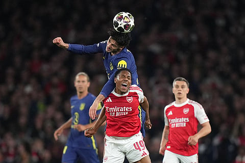 Atletico Madrid's Johnny Cardoso, top, fouls Arsenal's Myles Lewis-Skelly during a Champions League semifinal, second leg, soccer match between Arsenal FC and Atletico Madrid in London.