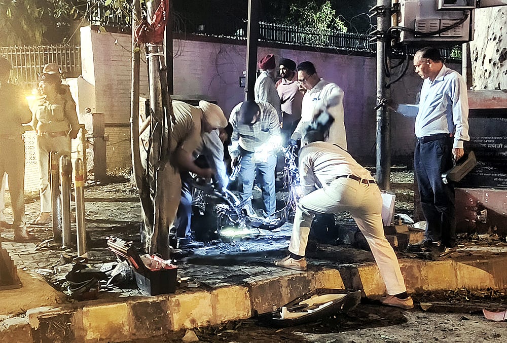 Security personnel inspect burnt scooter near BSF headquarters in Jalandhar
