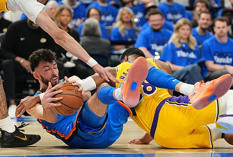 Oklahoma City Thunder's Chet Holmgren, left, competes for a loose ball against Los Angeles Lakers' Jaxson Hayes, left, and Rui Hachimura, right, in the second half of Game 1 in a second-round NBA basketball playoffs series in Oklahoma City. 