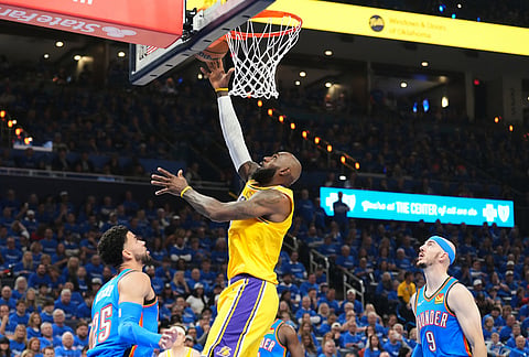 Los Angeles Lakers forward LeBron James shoots between Oklahoma City Thunder's Ajay Mitchell (25) and Alex Caruso (9) in the first half of Game 1 in a second-round NBA basketball playoffs series in Oklahoma City. 