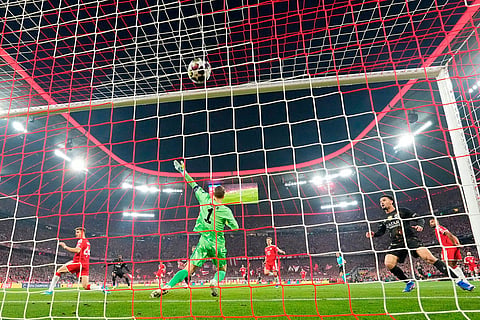 PSG's Ousmane Dembele, background left, scores the opening goal of his team during the Champions League semifinal second leg soccer match between Bayern Munich and Paris Saint Germain in Munich, Germany.