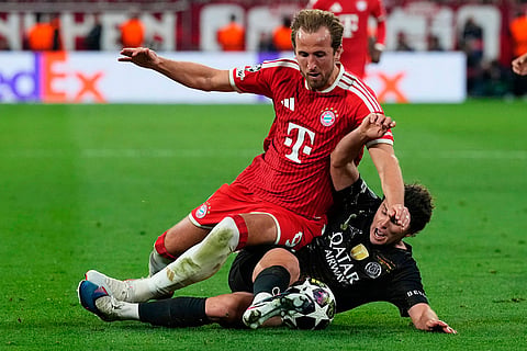 PSG's Joao Neves, bottom, stops Bayern's Harry Kane during the Champions League semifinal second leg soccer match between Bayern Munich and Paris Saint Germain in Munich, Germany.