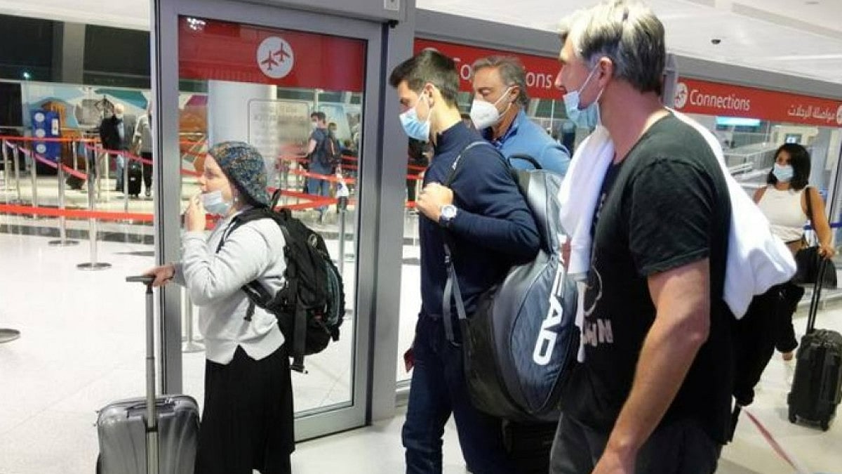 Novak Djokovic (C) arrives at Dubai International Airport after his deportation from Australia.
