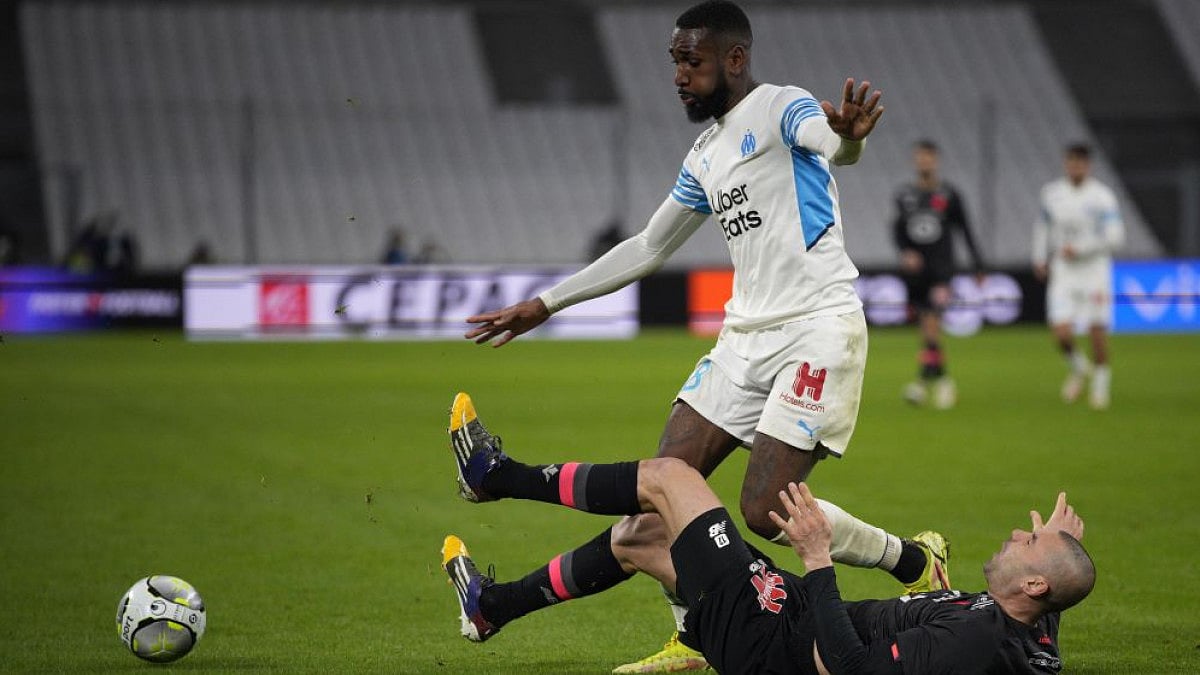 Marseille's Gerson (top) vies for the ball with Lille's Burak Yilmaz on January 16, 2022.