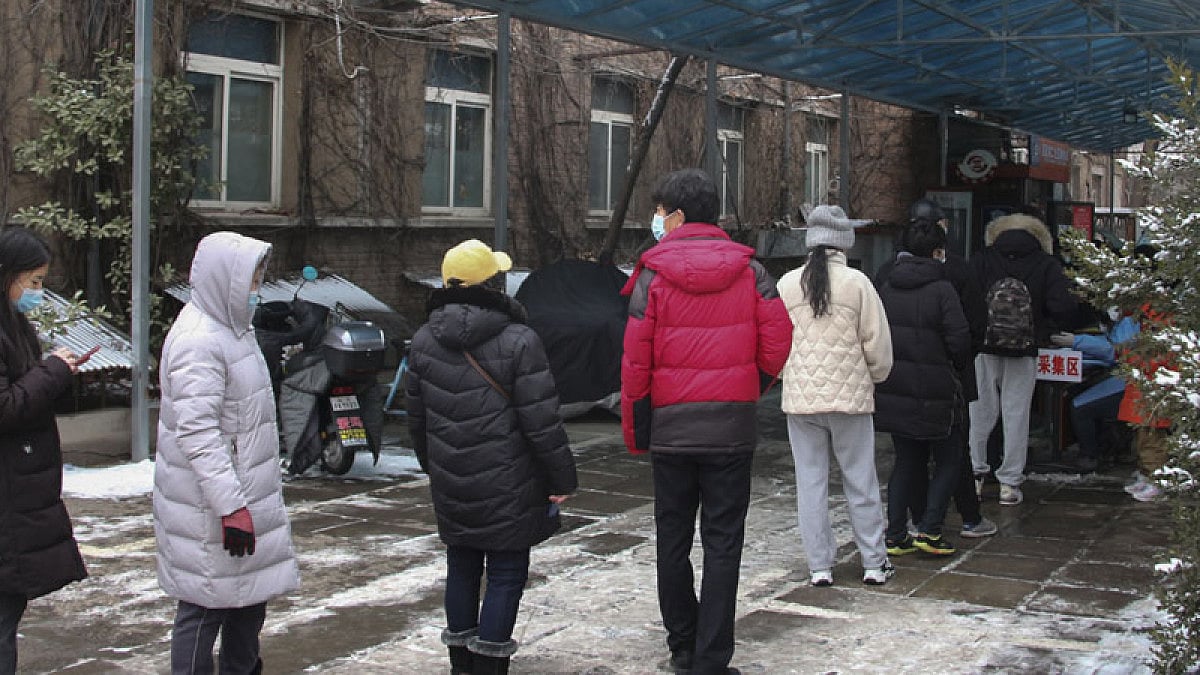 Residents line up to get a throat swab for the COVID-19 test at a residential area in Fengtai.