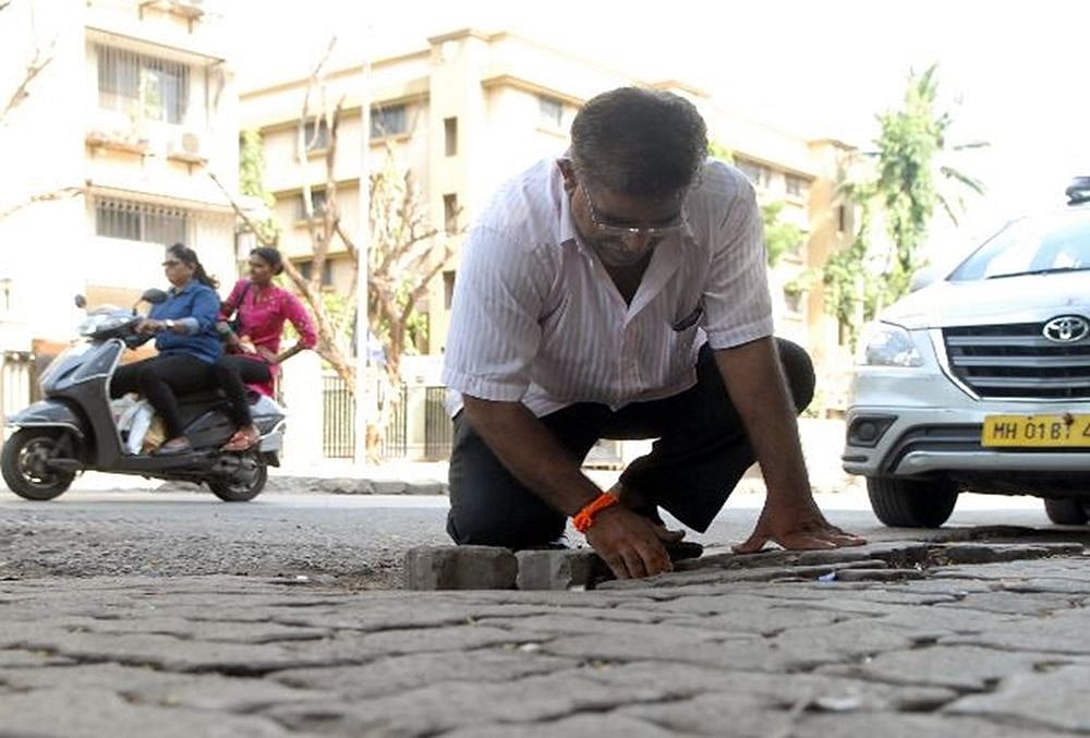 Mumbai man fills 556th pothole to mark his 16-year-old sons death.