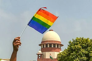 An activist waves a rainbow flag (LGBT pride flag) after the Supreme Court verdict which decriminalises consensual gay sex, outside the Supreme Court in New Delhi.