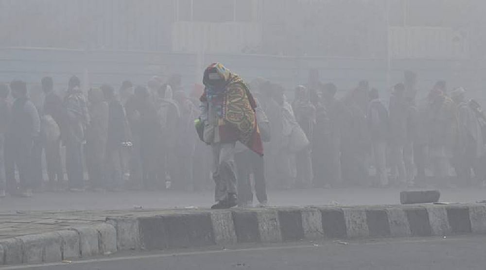 An elderly man wrapped in warm clothes on a cold, foggy morning, in New Delhi.