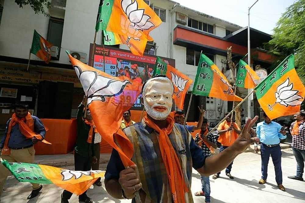 A supporters of Bharatiya Janata Party wears mask of Prime Minister Narendra Modi as he celebrates partys victory in general elections in Ahmadabad.