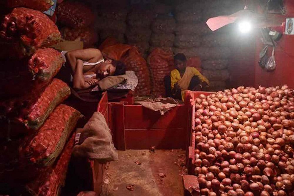 Vendors at a wholesale market wait for customers to buy onions as the vegetable prices continue to soar in the country. 