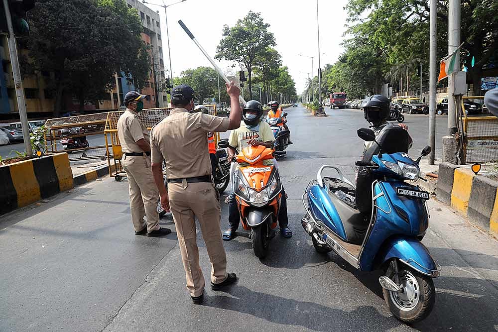 Police officers stop motorists as part of enforcing a countrywide lockdown in Mumbai.
