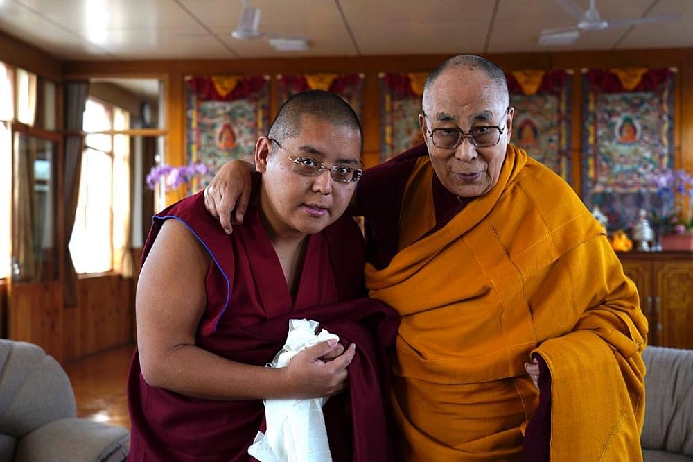 Dalai Lama poses with a follower.