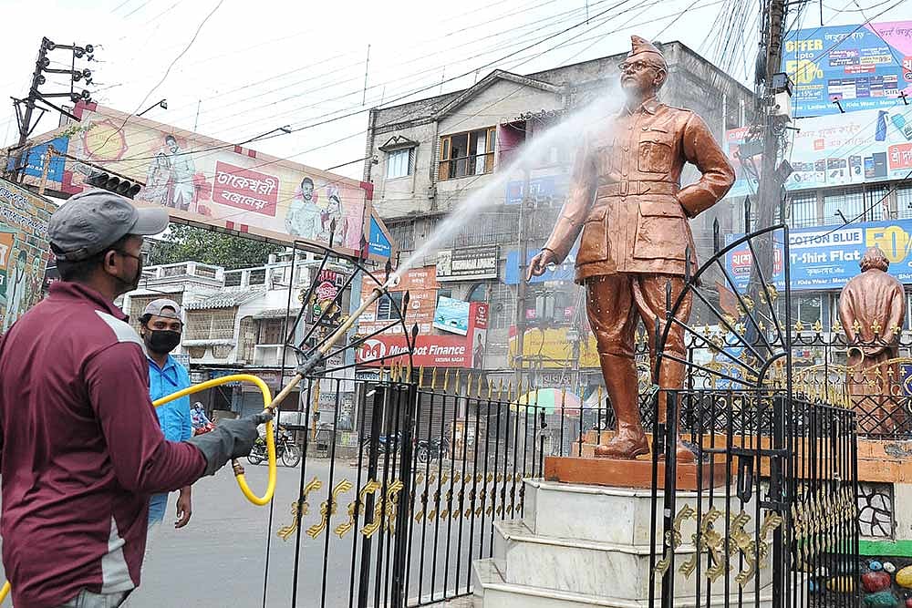 A civic worker sprays disinfectant on the statue of Netaji Subhash Chandra Bose at Krishnanagar during ongoing COVID-19 lockdown in Nadia district.