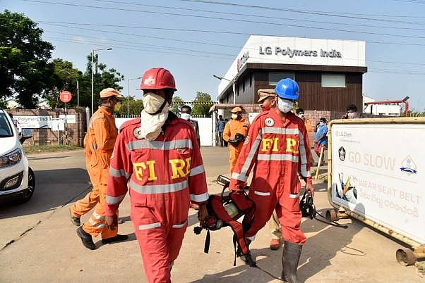 Firefighters walk with oxygen cylinders outside LG Polymers plant, the site of a chemical gas leak, in Vishakhapatnam. 