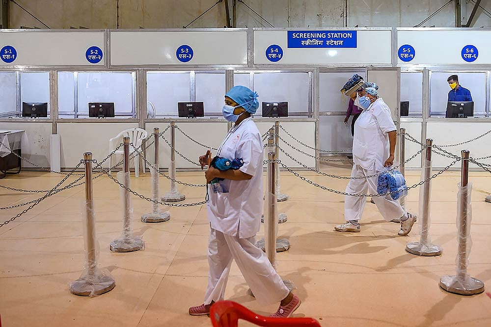 Nurses from Tata Memorial Hospital walk inside a temporary facility created to aid cancer patients diagnosed with COVID-19, in Mumbai.