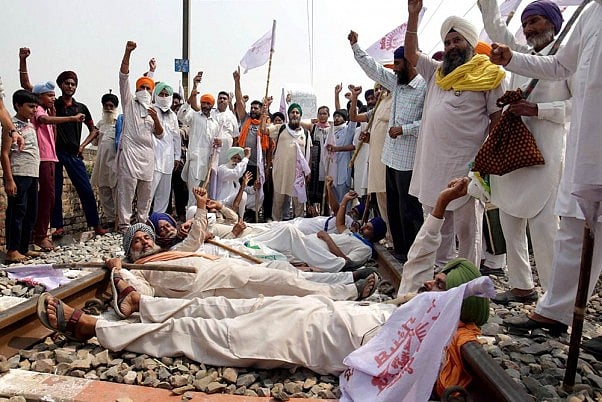 Farmers block a railway track as they participate in Rail Roko Andolan  against the farm bills